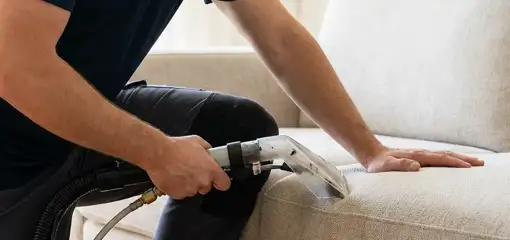 Professional upholstery cleaner deep-cleaning a fabric sofa with a handheld extraction tool, Aurora, IL.